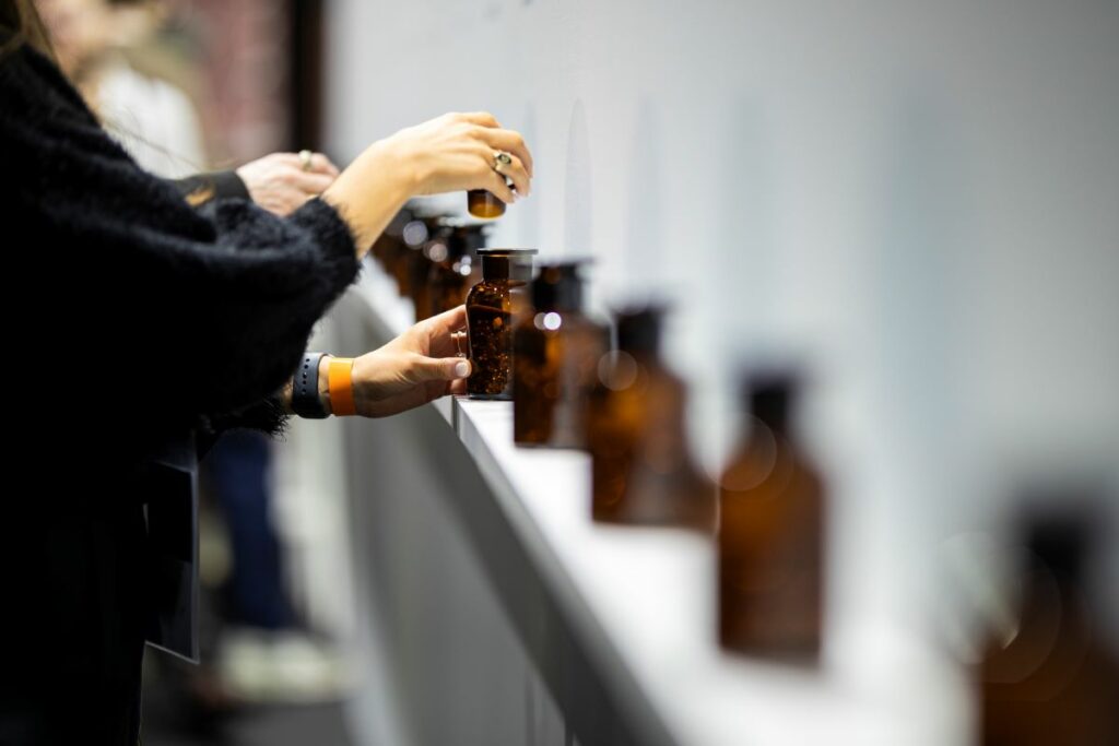 Person examines perfume bottle in brand creation laboratory — BOLD Factory